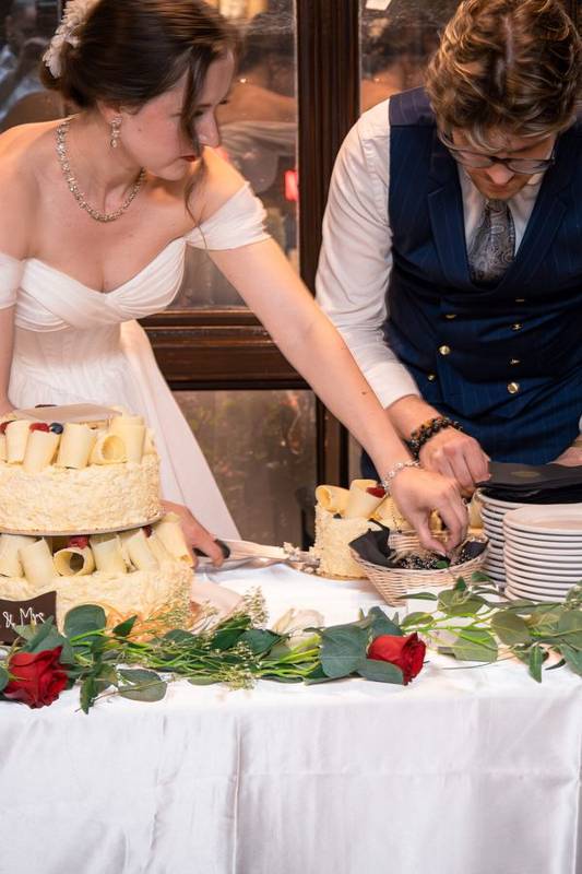 Couple laughing as they cut their wedding cake